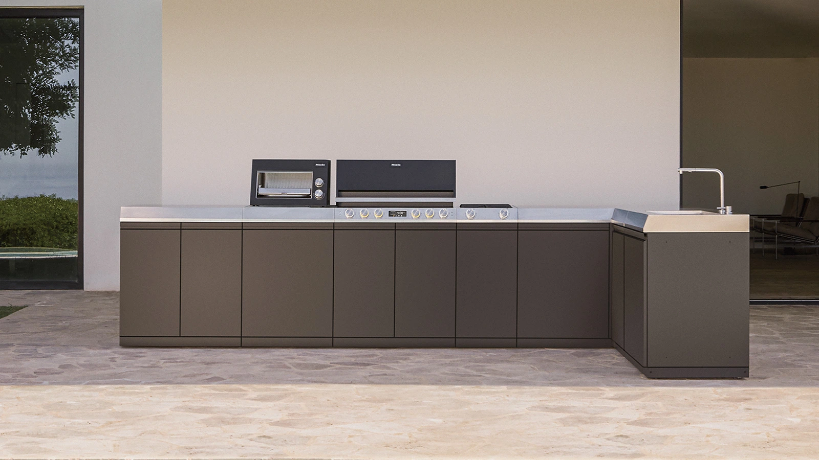 Terassenbereich mit einer hochwertigen Outdoorküche mit Miele Hausgeräten