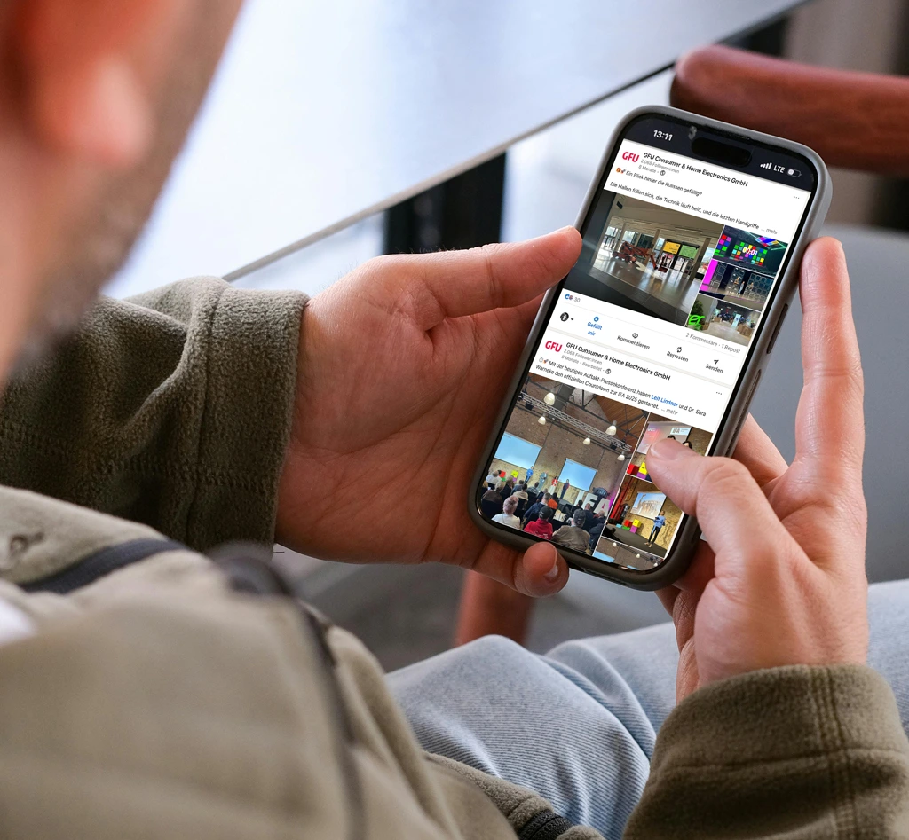 Mann scrollt auf dem LinkedIN-Profil der GFU auf seinem Smartphone