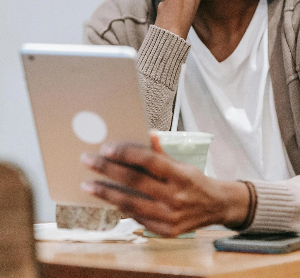 Frau hält ein Tablet PC während des Lesens des GFU Newsletters