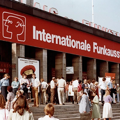 Besuchergruppe vor Eingang der Internationalen Funkausstellung 2005, rotes Messebanner, Treppen und Menschenansammlung