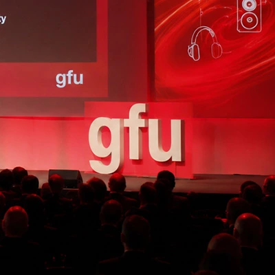 Konferenzbühne 2014 mit großem weißen 'gfu'-Logo, roter Beleuchtung und Publikum im Vordergrund
