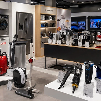 Elektronikfachgeschäft 2017: Ausstellung mit Küchengeräten, Staubsaugern, Kaffeemaschinen und Rasierern auf Verkaufstischen